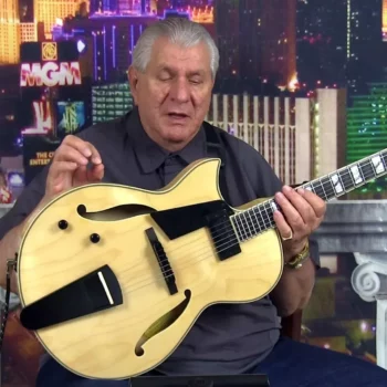 Robert Conti holding a Conti 15 inch left handed Entrada archtop jazz guitar in Natural Blonde finish